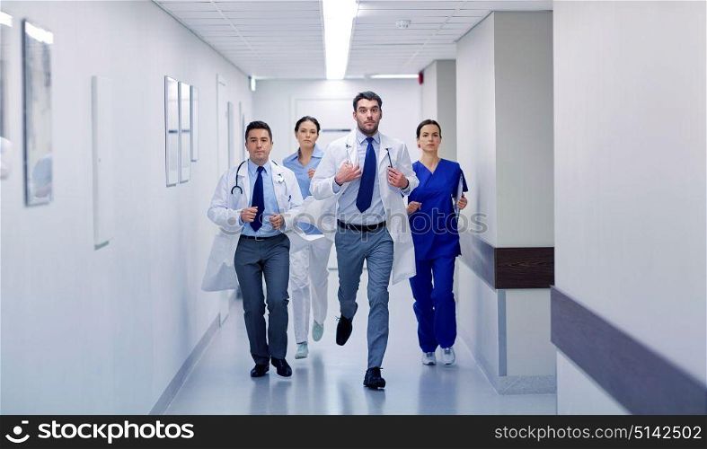 clinic, people, health care and medicine concept - group of medics runing along hospital. group of medics walking along hospital