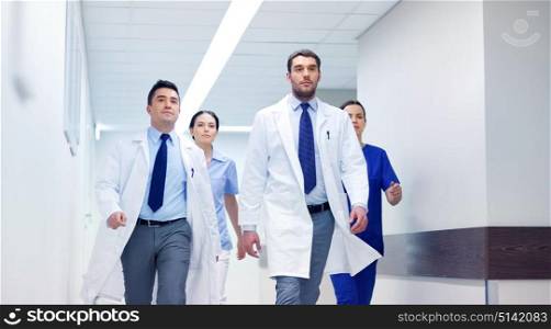 clinic, people, health care and medicine concept - group of medics walking along hospital. group of medics walking along hospital