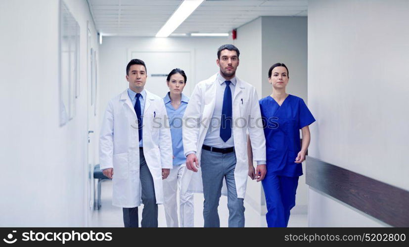clinic, people, health care and medicine concept - group of medics walking along hospital. group of medics walking along hospital