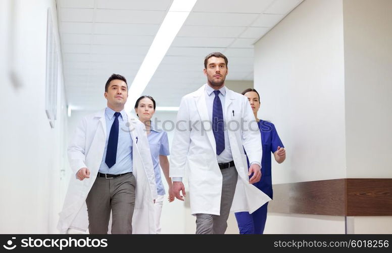 clinic, people, health care and medicine concept - group of medics walking along hospital