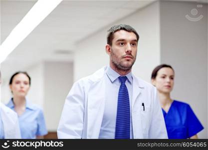 clinic, people, health care and medicine concept - group of medics walking along hospital