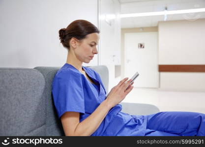 clinic, people, health care, technology and medicine concept - female doctor or nurse with smartphone at hospital