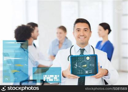 clinic, profession, people and medicine concept - happy male doctor showing tablet pc computer blank screen over group of medics meeting at hospital. happy doctor with tablet pc over team at clinic