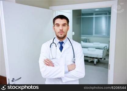 clinic, profession, people, health care and medicine concept - doctor with stethoscope at hospital corridor