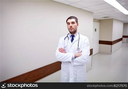 clinic, profession, people, health care and medicine concept - doctor with stethoscope at hospital corridor