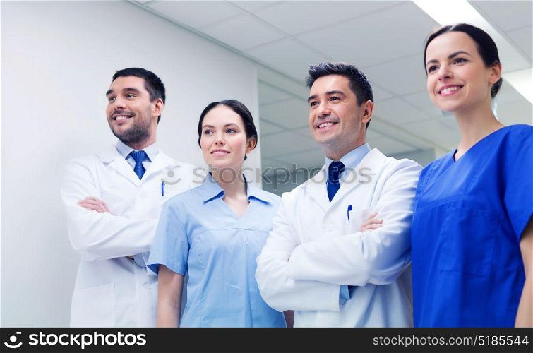 clinic, profession, people, health care and medicine concept - group of happy medics or doctors at hospital corridor. group of happy medics or doctors at hospital