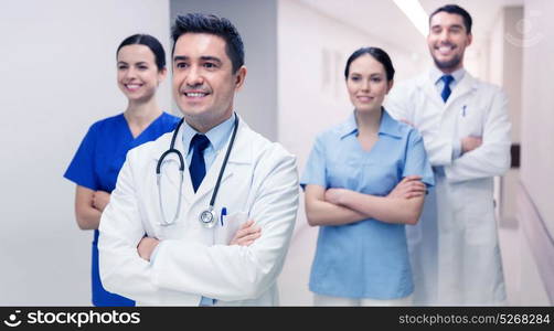 clinic, profession, people, health care and medicine concept - group of happy medics or doctors at hospital corridor. group of happy medics or doctors at hospital