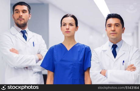 clinic, profession, people, health care and medicine concept - group of medics or doctors at hospital corridor. group of medics or doctors at hospital