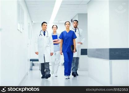 clinic, profession, people, health care and medicine concept - group of medics or doctors at hospital corridor. group of medics or doctors at hospital corridor