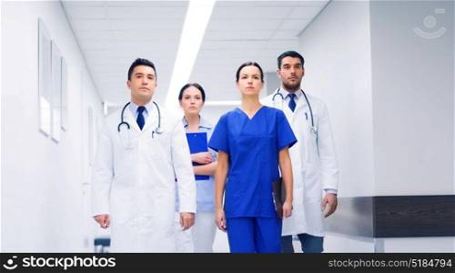 clinic, profession, people, health care and medicine concept - group of medics or doctors at hospital corridor. group of medics or doctors at hospital corridor