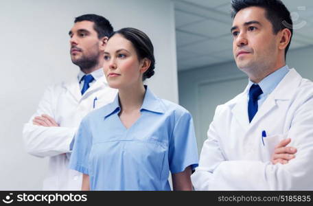 clinic, profession, people, health care and medicine concept - group of medics or doctors at hospital corridor. group of medics or doctors at hospital