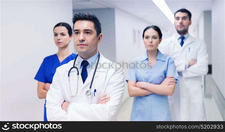 clinic, profession, people, health care and medicine concept - group of medics or doctors at hospital corridor. group of medics or doctors at hospital