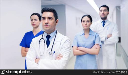 clinic, profession, people, health care and medicine concept - group of medics or doctors at hospital corridor. group of medics or doctors at hospital