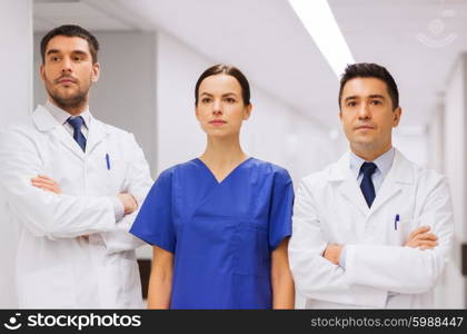 clinic, profession, people, health care and medicine concept - group of medics or doctors at hospital corridor