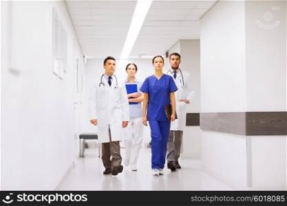 clinic, profession, people, health care and medicine concept - group of medics or doctors at hospital corridor