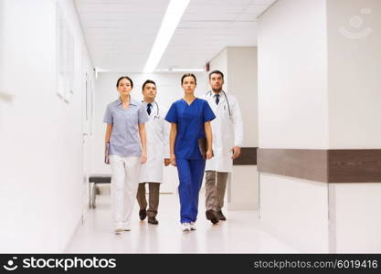 clinic, profession, people, health care and medicine concept - group of medics or doctors at hospital corridor