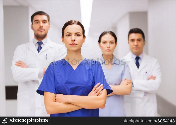 clinic, profession, people, health care and medicine concept - group of medics or doctors at hospital corridor