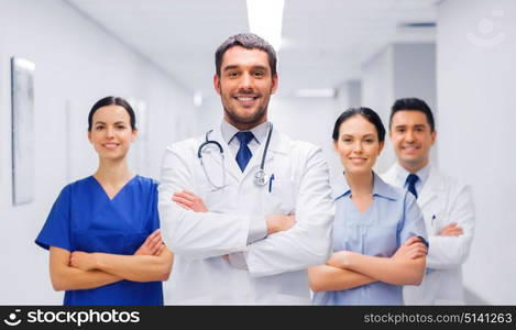 clinic, profession, people, health care and medicine concept - happy group of medics or doctors at hospital corridor. happy group of medics or doctors at hospital