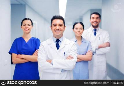 clinic, profession, people, health care and medicine concept - happy group of medics or doctors at hospital corridor. happy group of medics or doctors at hospital