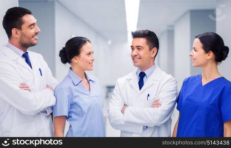 clinic, profession, people, health care and medicine concept - happy group of medics or doctors at hospital corridor. happy group of medics or doctors at hospital