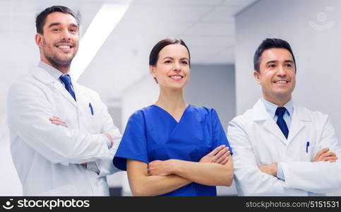 clinic, profession, people, health care and medicine concept - happy group of medics or doctors at hospital corridor. happy group of medics or doctors at hospital