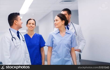 clinic, profession, people, health care and medicine concept - happy group of medics or doctors at hospital corridor. happy group of medics or doctors at hospital