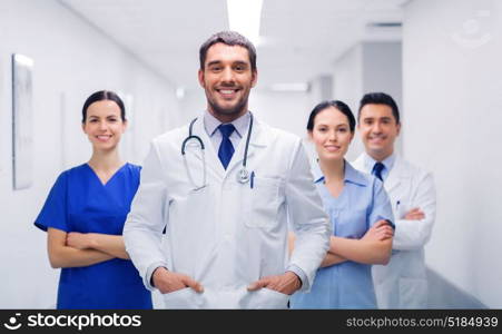 clinic, profession, people, health care and medicine concept - happy group of medics or doctors at hospital corridor. happy group of medics or doctors at hospital