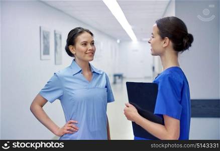 clinic, profession, people, health care and medicine concept - nurses or doctors talking at hospital. medics, nurses or doctors talking at hospital