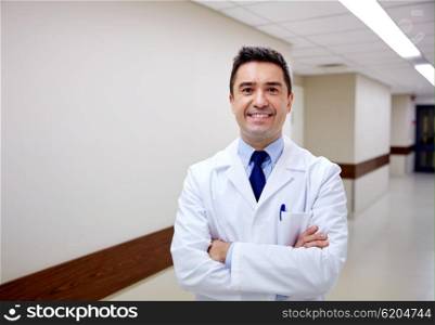 clinic, profession, people, health care and medicine concept - smiling doctor at hospital corridor