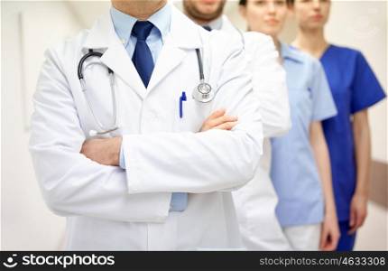 clinic, profession, people, healthcare and medicine concept - close up of medics or doctors at hospital corridor