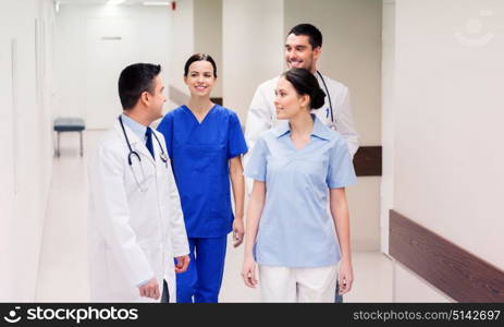clinic, profession, people, healthcare and medicine concept - group of happy medics or doctors at hospital corridor. group of happy medics or doctors at hospital