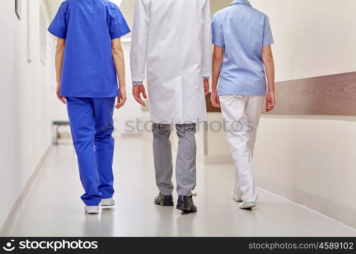 clinic, profession, people, healthcare and medicine concept - group of medics or doctors walking along hospital corridor