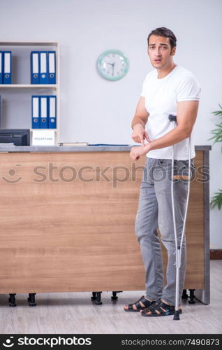 Clinic reception counter and young patient. Young man at hospital reception desk