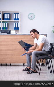 Clinic reception counter and young patient. Young man at hospital reception desk