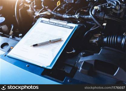 Clipboard on car with car insurance claim form for customer maintenance vehicle checklist in auto repair shop garage. Engine repair service concept. Business technical mechanics support for fixing car