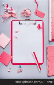 Clipboard with empty copy space blank for list or for input the text, flowers and other supplies, Top view, flat lay. Modern feminine office desk table in pink color