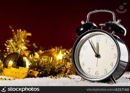 clock and christmas toys on snow on red background
