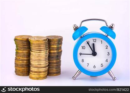 Clock and stacks of coins are close by, close-up