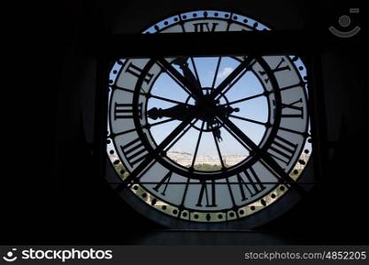 Clock at the Musee D'Orsay in Paris France. In the back we see the Sacre Coeur Basilica in Montmatre