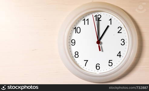 Clock hanging on wall ticking showing one hour. Clock ticking showing one hour