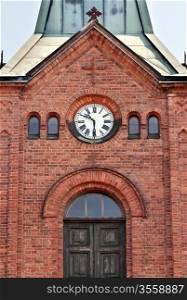 clock on the old brick Catholic Church in Europe