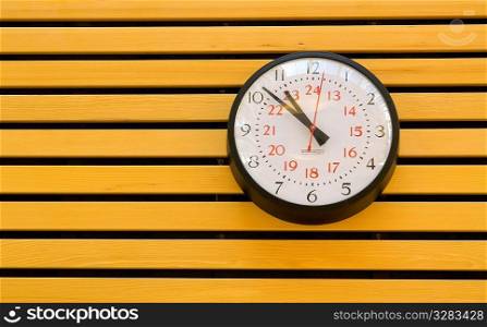 Clock on wooden slatted wall.