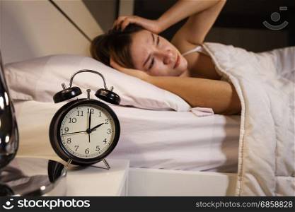 clock show 2 O&rsquo;clock and woman sleepless on the bed