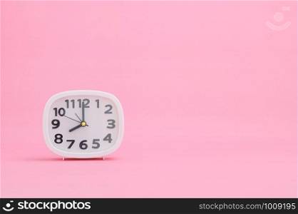 clock showing time on a pink background
