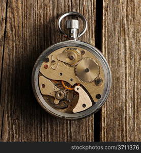 Clockwork mechanism over wooden background