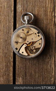 Clockwork mechanism over wooden background