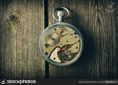 Clockwork mechanism over wooden background