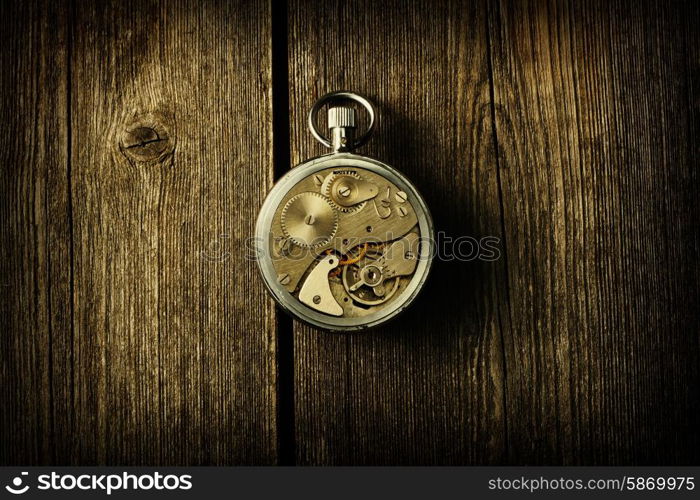 Clockwork mechanism over wooden background