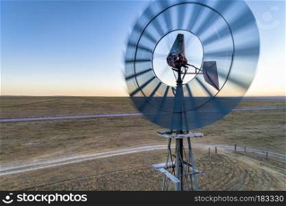 Close aerial view at old wind mill and water pump in prairie of northern COlorado