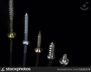 close five screws of various sizes in scale on black